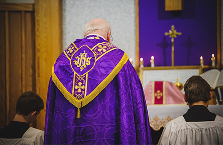 Catholic Priest wearing royal purple and gold during mass at St. John Cantius Church
